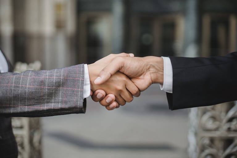 A close-up of two businesspeople shaking hands, symbolizing cooperation and partnership.
