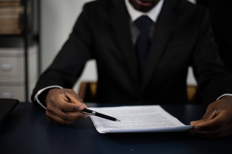 Close-up of a professional in a suit reviewing a document with focused attention.